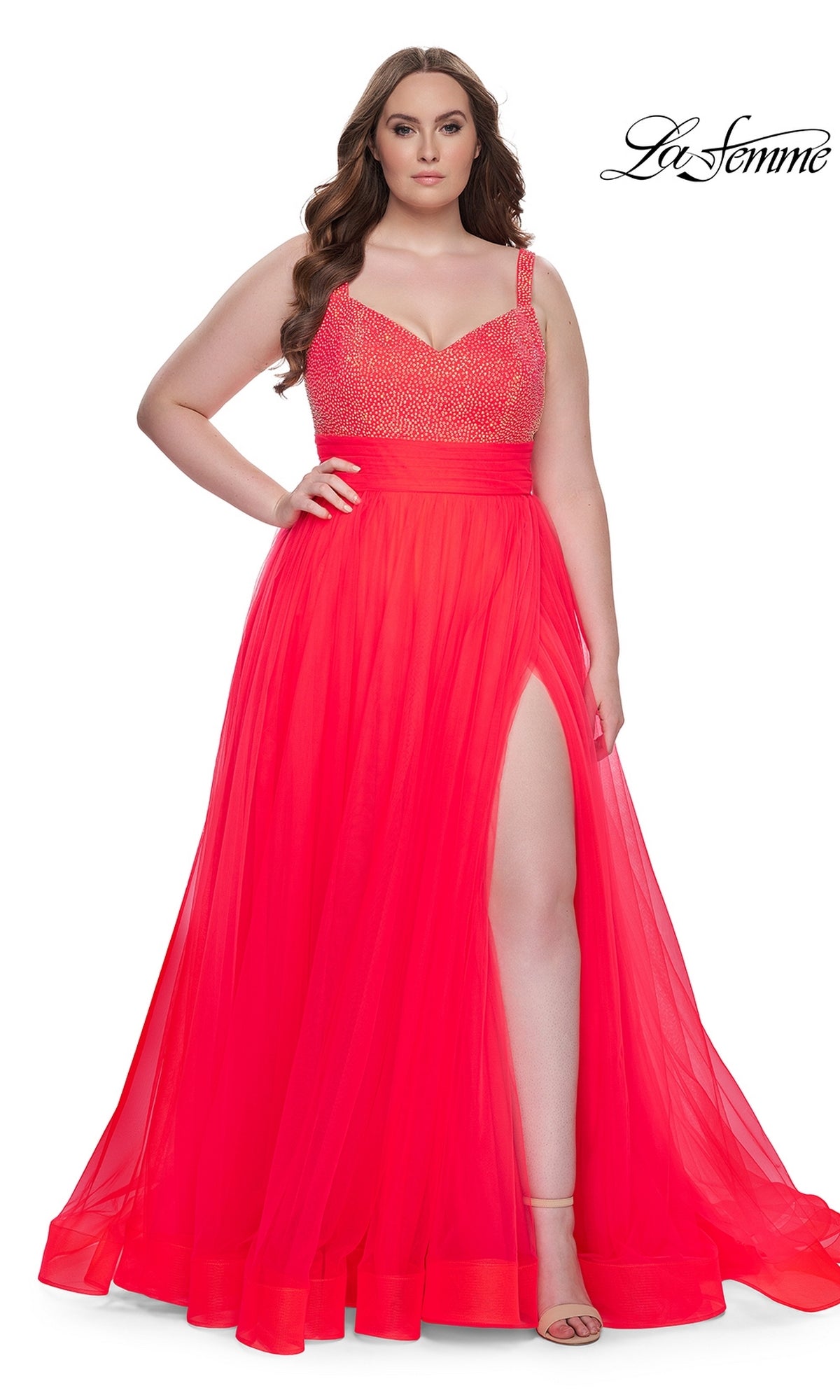 A woman stands confidently with one hand on her hip, wearing the La Femme Long Prom Dress 31251 in Hot Coral—a sleeveless gown with a beaded bodice and high slit. The La Femme logo appears in the top right corner.